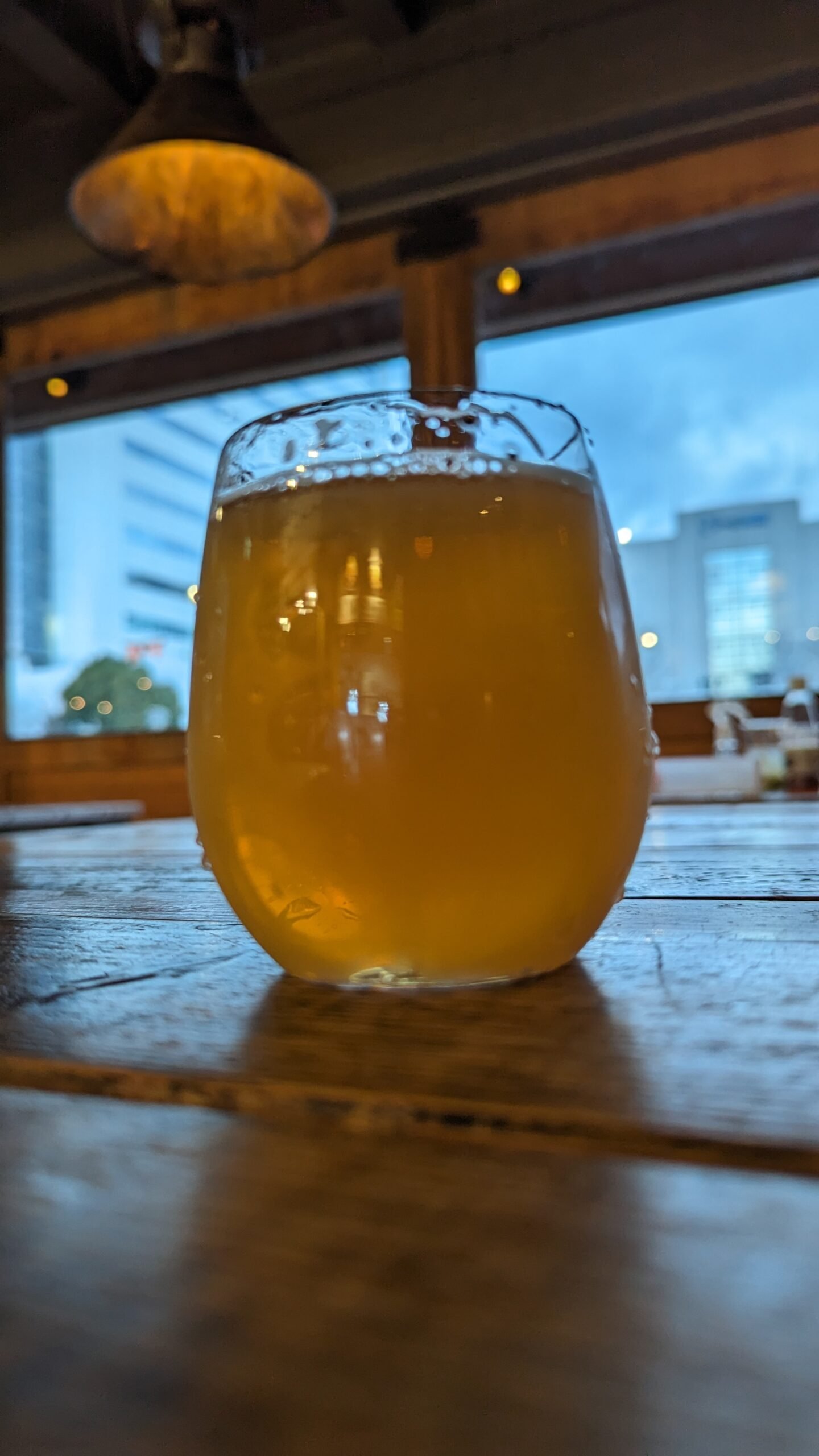 Beer stand MARCAで提供されたビールと、TUGBOAT TAISHOの木のテーブルと川側の窓