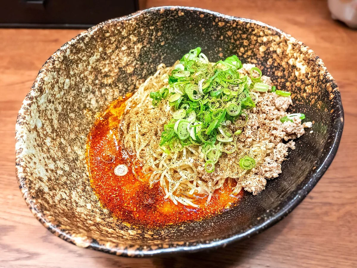 キング軒の汁なし担担麺。麺の上にねぎとひき肉、器の底に辣油のたれ
